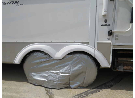 ADCO Silver Vinyl Double Axle Tire Cover Installed on RV - Lifestyle Side View | United RV Parts
