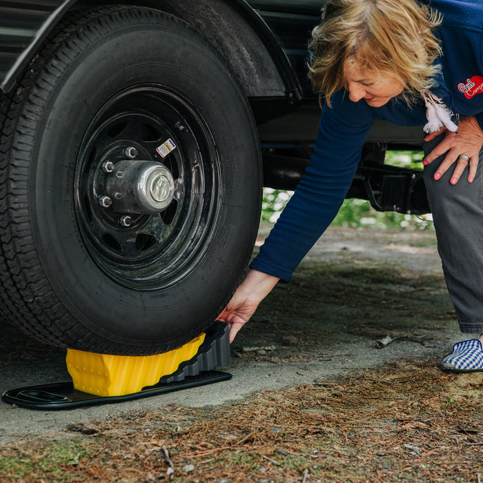 Woman Using Yellow Camco Wheel Chock - In-Use Application | United RV Parts