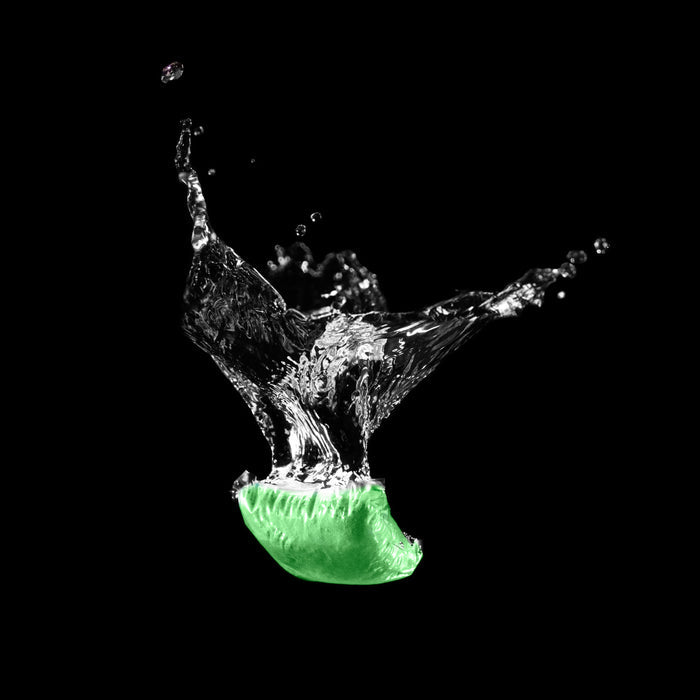 Green Camco TST Drop-In RV black water tank treatment packet splashing in water - Action Detail | United RV Parts