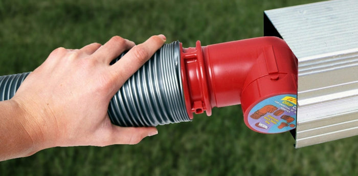 Hand Holding Red RV Sewer Hose Adapter Connected to Black Corrugated Hose - In Use | United RV Parts