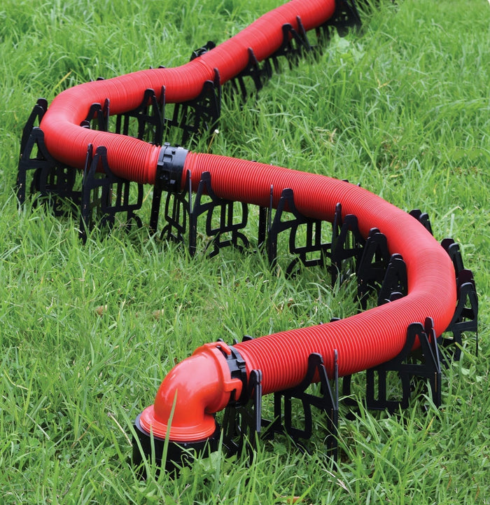 Valterra Slunky RV Sewer Hose Support Cradles Supporting Red Hose on Grass - In-Use View | United RV Parts
